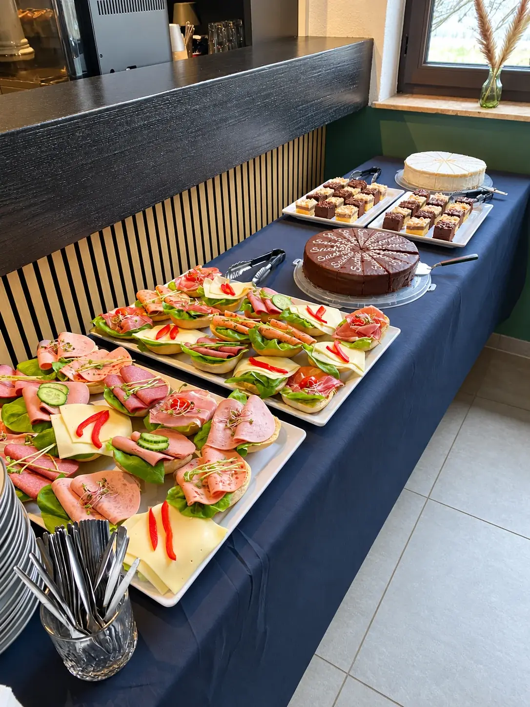 Platten mit belegten Brötchen und Kuchenauswahl